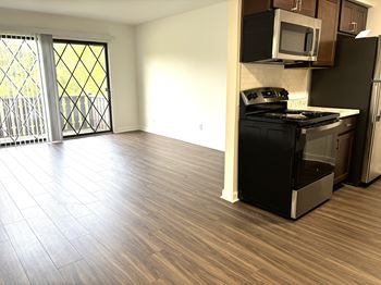 A kitchen with a black stove top oven and a microwave above it.